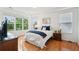 Bright bedroom featuring a large window, wood floors, and tray ceiling at 2267 N Marsh Dr, Mount Pleasant, SC 29466