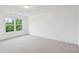 A bedroom space with neutral carpet and a large window overlooking verdant greenery at 2267 N Marsh Dr, Mount Pleasant, SC 29466