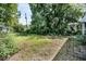 View of the backyard featuring overgrown grass and dense shrubbery and trees at 2373 Sorentrue Ave, North Charleston, SC 29405