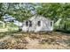 Exterior view of the home featuring a grass yard, trees, wood siding, and multiple windows at 2373 Sorentrue Ave, North Charleston, SC 29405