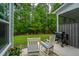 Inviting back patio features relaxing chairs and a grill, perfect for outdoor enjoyment with wooded view at 2402 Brackish Dr, Mount Pleasant, SC 29466