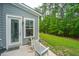 Relaxing back porch with two chairs, lovely gray siding, and a view of the green lawn with bordering trees at 2402 Brackish Dr, Mount Pleasant, SC 29466