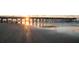 Sunset view of a pier stretching out over the beach, with reflections of the light on the wet sand at 2402 Brackish Dr, Mount Pleasant, SC 29466