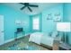 This aqua bedroom has a window, bed, ceiling fan, bedside tables, a rug, and coastal decor at 2402 Brackish Dr, Mount Pleasant, SC 29466