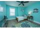 This aqua bedroom has a window, bed, ceiling fan, bedside tables, and a colorful area rug at 2402 Brackish Dr, Mount Pleasant, SC 29466