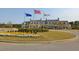 View of clubhouse featuring manicured lawn and landscaping, with flagpoles displaying the American flag at 2402 Brackish Dr, Mount Pleasant, SC 29466