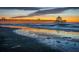 Beautiful sunset view of the pier, with reflections on the wet sand, and a tranquil ocean scene at 2402 Brackish Dr, Mount Pleasant, SC 29466