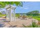 Outdoor sitting area with arbor and seating overlooking a tranquil pond with lush trees at 2931 Waterleaf Rd, Johns Island, SC 29455