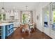 Cozy dining area with a round table, wicker chairs, a decorative chandelier, and seamless flow to the kitchen at 301 Center St, Mount Pleasant, SC 29464