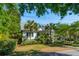 Charming two-story home with a cozy front porch, lush palm trees, and beautiful landscaping at 301 Center St, Mount Pleasant, SC 29464