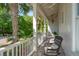 Relaxing front porch with a wicker chair and scenic neighborhood views at 301 Center St, Mount Pleasant, SC 29464