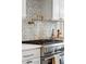Close-up of the kitchen featuring a high-end stainless steel range, pot filler, and detailed backsplash tile work at 301 Center St, Mount Pleasant, SC 29464