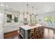 Spacious kitchen with large center island, white cabinets, modern appliances, and views of the backyard pool at 301 Center St, Mount Pleasant, SC 29464