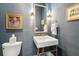 Elegant powder room featuring designer fixtures, stylish wallpaper, and decorative framed art at 301 Center St, Mount Pleasant, SC 29464