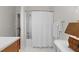 Bright bathroom features a tub-shower with white tiled walls, a white shower curtain, and white tile flooring at 3052 Seabrook Island Rd, Seabrook Island, SC 29455