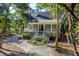 Stately house features a covered porch, mature landscaping and a circular driveway, all under a canopy of mature trees at 3052 Seabrook Island Rd, Seabrook Island, SC 29455