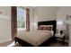 Cozy bedroom with a dark wood frame bed, side tables, modern lamps, and a large window at 336 Trailmore Ln, Summerville, SC 29486