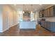 Open-concept kitchen with a central island, stainless steel appliances, gray cabinets, and laminate flooring at 408 Fox Sparrow Ct, Summerville, SC 29486