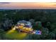 Beautiful two story home with a pool and spacious green yard and porch, all lit up in the evening at 4121 Golf Cottage Ln, Johns Island, SC 29455