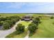 Breathtaking aerial shot of an estate home with circular driveway surrounded by mature landscaping near the golf course and river at 4121 Golf Cottage Ln, Johns Island, SC 29455