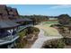 Multi-level building with a patio overlooking a lush green golf course and verdant landscaping at 4121 Golf Cottage Ln, Johns Island, SC 29455