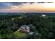 Stunning aerial view of estate home nestled in a lush landscape, with golf course and coastal views at sunset at 4121 Golf Cottage Ln, Johns Island, SC 29455