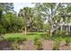 Secluded backyard featuring lush greenery, mature trees, and a charming outdoor area with a pool at 4121 Golf Cottage Ln, Johns Island, SC 29455