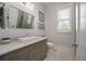 Tastefully designed bathroom with a white vanity, gray cabinets, and a framed mirror at 4121 Golf Cottage Ln, Johns Island, SC 29455