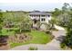 Stunning exterior view of the home showcasing lush landscaping, a circular driveway, and mature trees at 4121 Golf Cottage Ln, Johns Island, SC 29455
