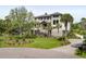 Spacious home with a well-manicured lawn, lush landscaping, and a charming front porch near a golf course at 4121 Golf Cottage Ln, Johns Island, SC 29455
