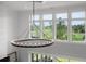 Soaring foyer with decorative light fixture and views of the golf course through expansive windows at 4121 Golf Cottage Ln, Johns Island, SC 29455