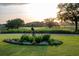 Lush green lawn with a bronze bird sculpture and colorful flower bed at 4121 Golf Cottage Ln, Johns Island, SC 29455
