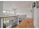 The second story hallway has wood floors, iron railings, and lots of natural light at 4121 Golf Cottage Ln, Johns Island, SC 29455