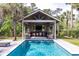 Beautiful outdoor kitchen and pool area with bar seating, a grill, and ample space for entertaining at 4121 Golf Cottage Ln, Johns Island, SC 29455