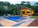 A custom outdoor pool with an open poolside pavilion, featuring a bar, a TV, and lounge seating at 4121 Golf Cottage Ln, Johns Island, SC 29455