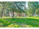 Backyard showing house with lots of trees and well maintained lawn at 441 Compton Dr, Moncks Corner, SC 29461