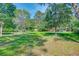 Expansive backyard with mature trees and small sheds for outdoor storage at 441 Compton Dr, Moncks Corner, SC 29461