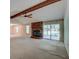Bright living room features a fireplace, vaulted ceiling with exposed beams, and sliding glass door access to the backyard at 441 Compton Dr, Moncks Corner, SC 29461