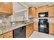 Bright kitchen featuring tile backsplash, stainless steel sink, and black appliances at 528 Sea Foam St, Summerville, SC 29486