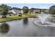 Aerial view of a serene pond with a fountain, nestled amidst houses and lush greenery at 528 Sea Foam St, Summerville, SC 29486