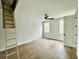 Bright bedroom featuring a ceiling fan and two windows offering outdoor views and a wooden ladder to the attic at 5702 Barbary Coast Rd, Hollywood, SC 29449