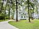 Beautifully landscaped home featuring a driveway and mature trees, offering shade and curb appeal at 5702 Barbary Coast Rd, Hollywood, SC 29449
