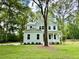 Inviting two-story home with a classic design and a well-maintained lawn, nestled among mature trees at 5702 Barbary Coast Rd, Hollywood, SC 29449