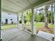 Relaxing front porch featuring stately columns, a concrete floor, and views of the lush front yard at 5702 Barbary Coast Rd, Hollywood, SC 29449