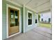 Cozy front porch with a stylish door, offering an inviting entrance to the home and views of the neighborhood at 5702 Barbary Coast Rd, Hollywood, SC 29449