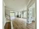 Open-concept living room with wood floors, fireplace, and plenty of natural light from large windows and sliding glass doors at 5702 Barbary Coast Rd, Hollywood, SC 29449
