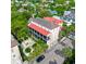 Aerial view of a grand building with a red roof surrounded by lush greenery and neighborhood houses at 81 Rutledge Ave, Charleston, SC 29401