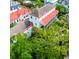 Aerial view highlighting a classic home with a red roof, set amongst lush green trees and neighboring houses at 81 Rutledge Ave, Charleston, SC 29401