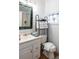Well-lit bathroom with a vanity sink, toilet, and a stand with neatly stacked towels at 81 Rutledge Ave, Charleston, SC 29401