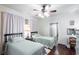 Bright bedroom with twin beds, hardwood floors, and soft lilac curtains at 81 Rutledge Ave, Charleston, SC 29401